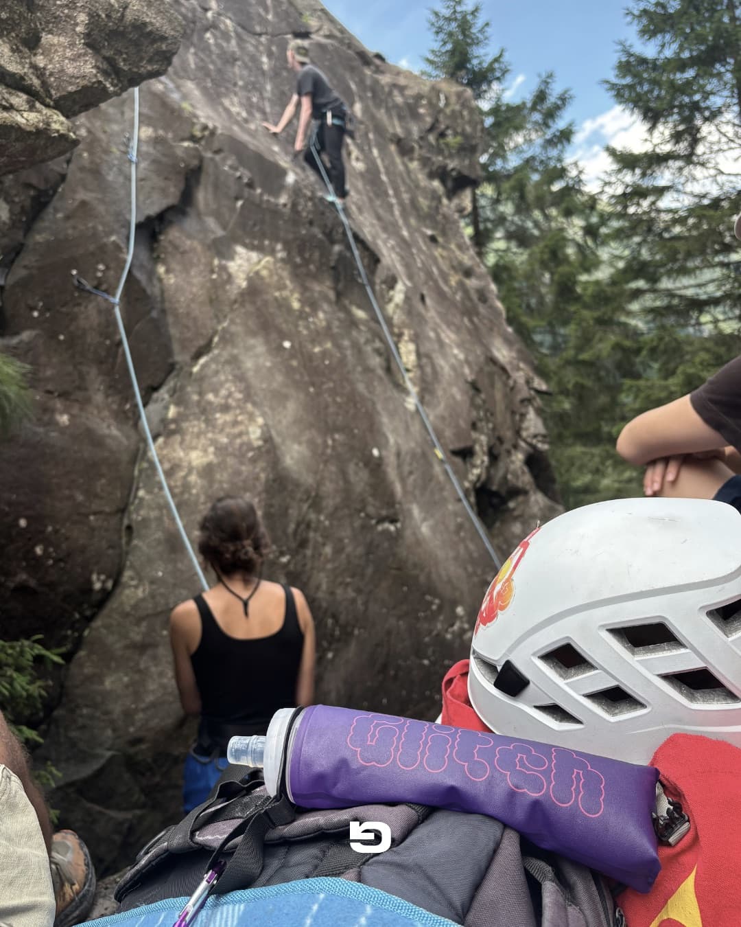 Climbers on a rock face with a Glitch bottle in the foreground