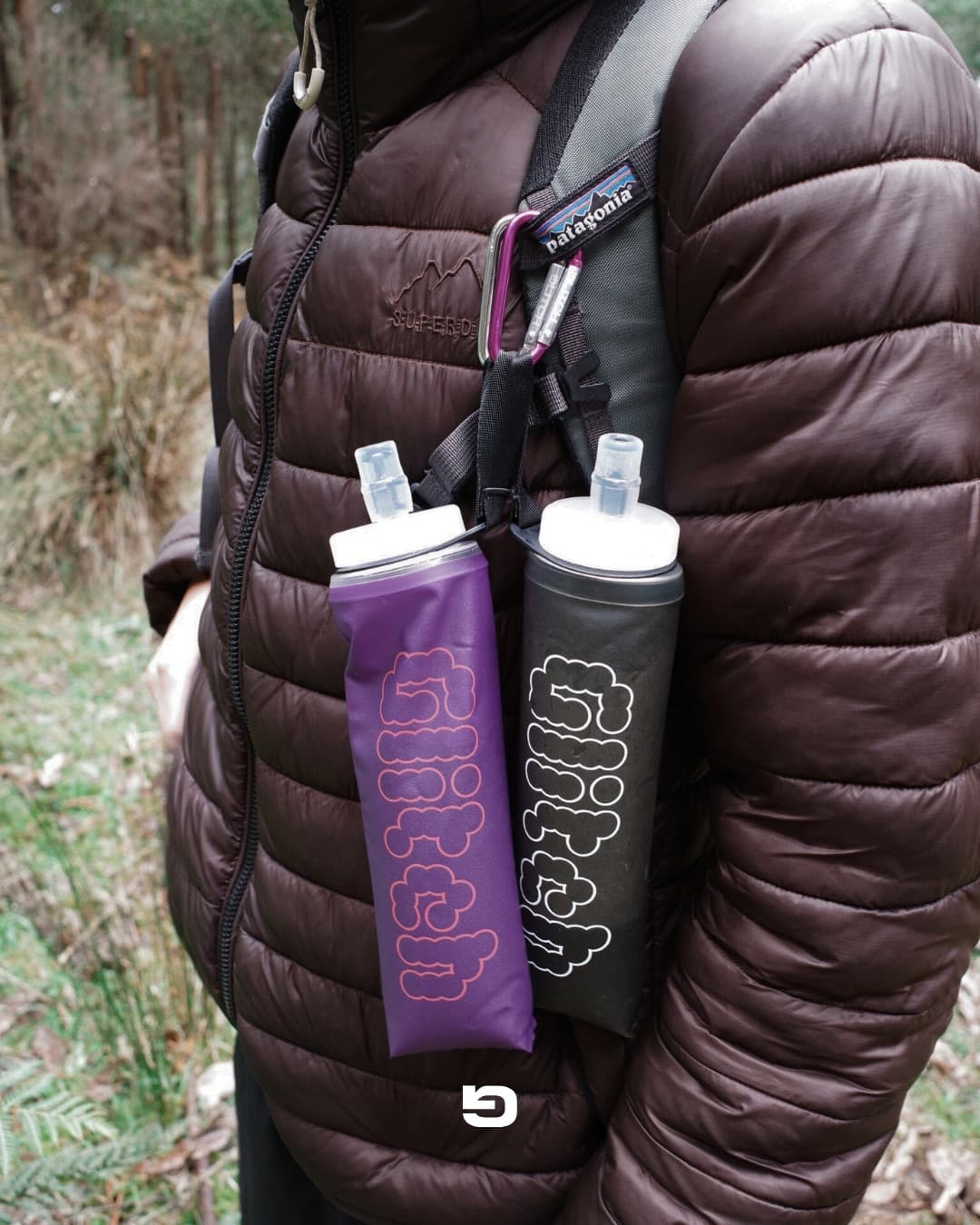 Two Glitch soft flasks clipped to a backpack strap